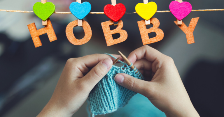 Close-up of hands knitting with wooden needles, showcasing creativity and focus, with colorful letters spelling 'HOBBY' in the background, perfect for illustrating the concept of turning a hobby into a business.