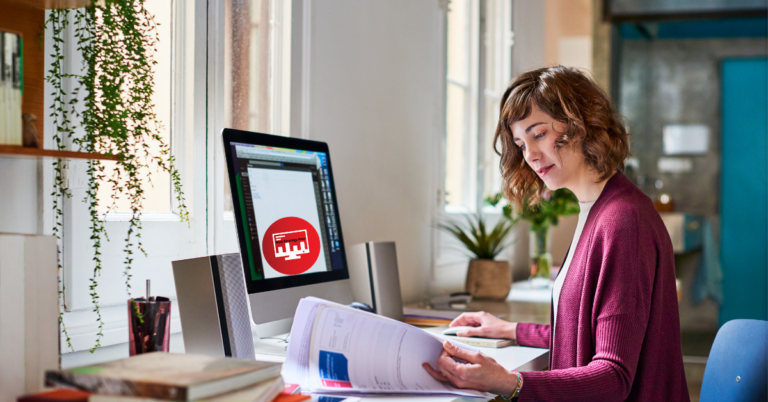 Young professional working on a home-based business idea at a desk, with a computer displaying creative projects, highlighting the benefits of starting a good home-based business from a comfortable and inspiring workspace.